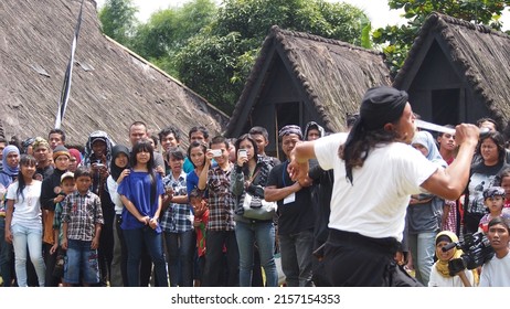 West Java, Indonesia - December 2, 2012 : The Audience Of The Show Was Amazed To See An Old Man Showing Off His Immune Skills By Playing A Machete In His Mouth