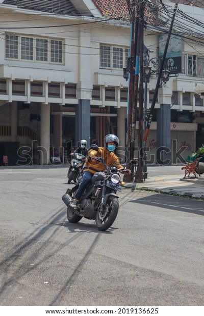 West Java, Indonesia - May 26, 2021 : A man rides a\
classic Yamaha XSR motorcycle at a road bend in Bandung, West Java\
on May 26, 2021.