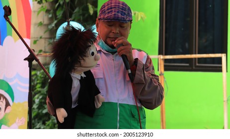 WEST JAVA JUNE 2021 - A Ventriloquist Holding His Doll While Telling A Story