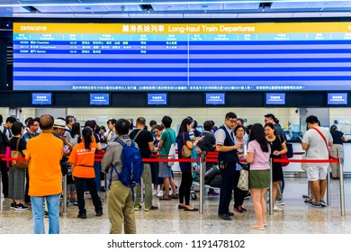 WEST KOWLOON, HONG KONG - SEP 29, 2018: Passenger Queuing At The Ticket Office With A Screen Showing Rail Timetable  At The West Kowloon High Speed Rail Station For High Speed Rail Tickets To China