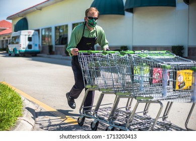 West Palm Beach, Fl USA 04/23/2020 Publix Grocery Store Worker Returning Carts To Store From Parking Lot With Face Mask