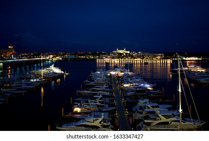 West Palm Beach, FL/USA - 12/14/19: Nightime Picture Of Palm Harbor Marina. Yachts, Palm Beach A The Breakers In The Background.