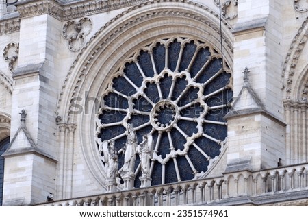 The West Rose Window: Notre Dame Cathedral. The statues in front depict the Virgin and Child flanked by two angels. Paris, France