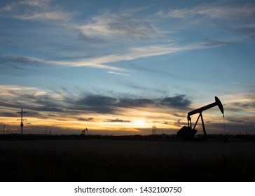 West Texas Oil Field Pump Jack In The Sunset, In Silhouette