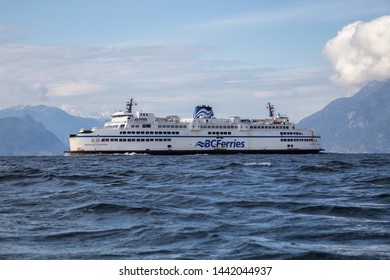 West Vancouver, British Columbia, Canada - April 21, 2019: View from the water perspective of BC Ferries Boat leaving the Horseshoe Bay Terminal during a sunny and cloudy day.