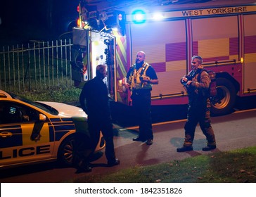 West Yorkshire,United Kingdom - 09/25/20 : UK Police Officer Liasing With The Fire Brigade At A Emergency Scene.A Police Car And A Fire Engine Can Be Seen.