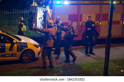 West Yorkshire,United Kingdom - 09/25/20 : UK Police Officer Liasing With The Fire Brigade At A Emergency Scene.A Police Car And A Fire Engine Can Be Seen.