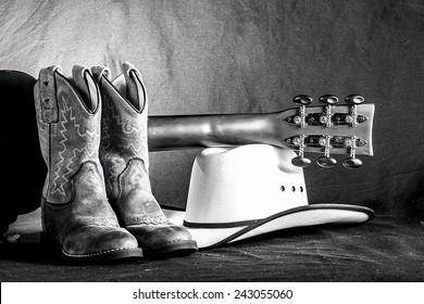 A western arrangement with cowboy boots, hat and an acoustic guitar.