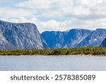 Western Brook Pond, a fjord formed by glacial erosion. Blue sky and white clouds, summer. Moose by the lake. -Gros Morne National Park of Canada, NL, Canada. 