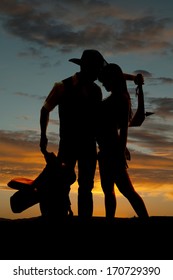 A Western Couple Is Standing In Front Of A Sunset. 