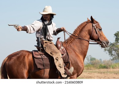 western cowboy portrait holding a gun on horseback