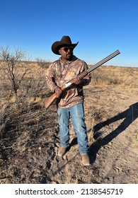 Western hunter wielding an over and under shotgun while hunting in open country.