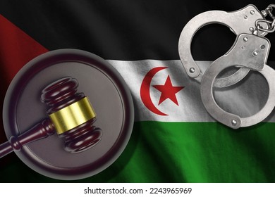 Western Sahara flag with judge mallet and handcuffs in dark room. Concept of criminal and punishment, background for guilty topics