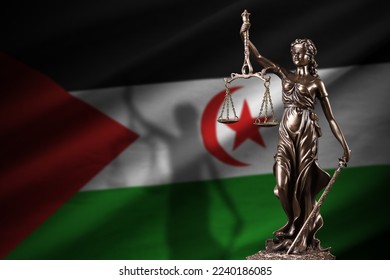 Western Sahara flag with statue of lady justice and judicial scales in dark room. Concept of judgement and punishment, background for jury topics