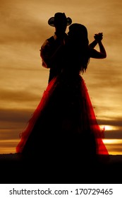 A western silhouette of a couple dancing together.