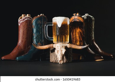 Western Wear Boots, Cow Skull, Pitcher Of Beer On Dark Background