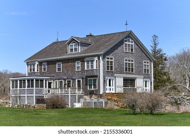 Westport, MA USA - April 23, 2022: A large barn converted to a summer house. Weathered wood shingles cover the facade and the roof with white trim on the windows and doors. 