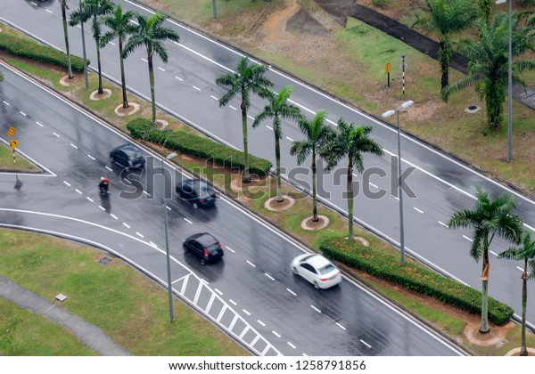 Wet asphalt road with\
cars, top view.  Raining streets, top view. Blurred photo with cars\
in motion.
