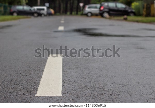 wet asphalt road with\
a dividing strip