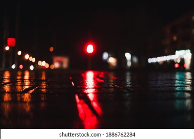 Wet Brick Road, Lights In The Background, City Out Of Focus At Night. Beautiful Night Photo Of The City In Out Of Focus