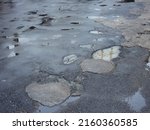 Wet bumpy asphalt road after rain in street