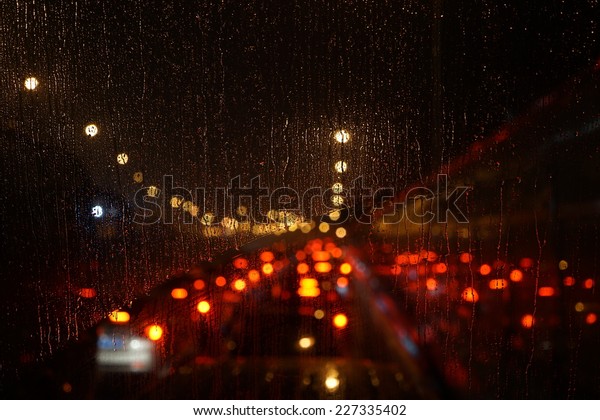Wet the car window with the background of the night
city traffic view.