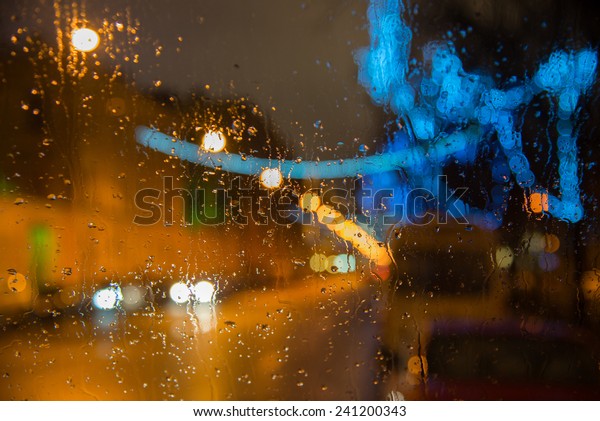 Wet the car window with the background of the
night city lights