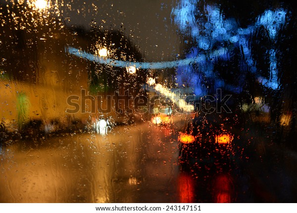 Wet the car window with the background of the\
night city lights