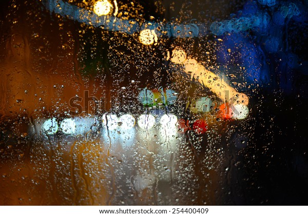 Wet the car window with the background of the\
night city lights