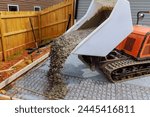 Wet cement is poured into framework using self dumping track concrete buggy during construction of foundation