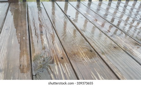Wet deck in the rain with reflection of rail