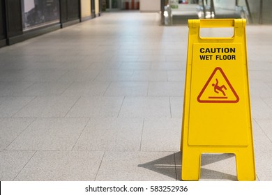 Wet Floor Caution Sign On Pathway In Office