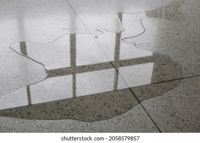 Wet Floor From Rainy Splash Or Pipelines Water Leakage In Office. Danger Accident At Home From Liquid Slippery Floor Hazard Concept.
