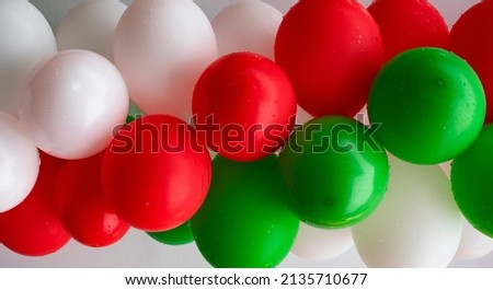 Wet green, white and red air balloons filled with helium, a symbol of national flag of Italy 