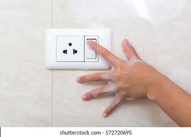 Wet Hand Of Children Trun On Electric Switch. Concept Of Do Not Use Electricity With Wet Hand And Safety Of Children.