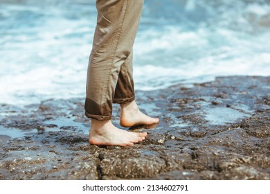 Wet Man Legs In Pants Walking By Sea Rocky Beach Enjoying Water. Summer Vacation