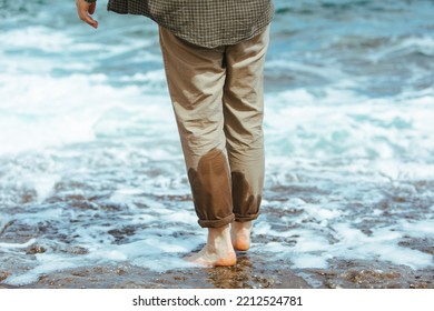 Wet Man Legs In Pants Walking By Sea Rocky Beach Enjoying Water. Summer Vacation