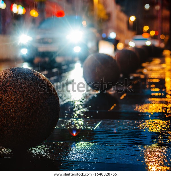 Wet night city street rain Bokeh reflection bright
colorful lights puddles sidewalk Car headlights lighting reflection
wet asphalt road Defocused selective focus fuzzy copy free space
for text.