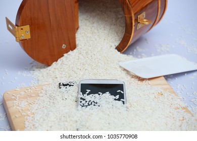 Wet Phone In Rice On Wood And Bucket Rice Background