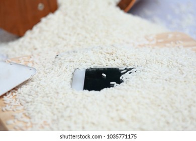 Wet Phone In Rice On Wood And Bucket Rice Background