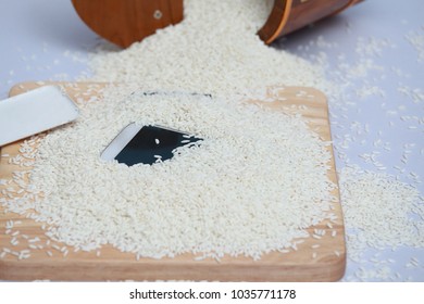 Wet Phone In Rice On Wood And Bucket Rice Background