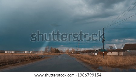 Wet road, storm clouds. In the background you can see a UFO. A ray of light from the sky. Unidentified flying objects that take on board, scattered objects for research. The Coloss.