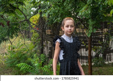 Wet Schoolgirl Standing In The Rain. Girl Wet. Teenager In School Uniform In Spring Or Warm Autumn. Girl 5th Grade. Hair Coloring. Portrait Of A Schoolgirl With Splashes Of Water. Back To School