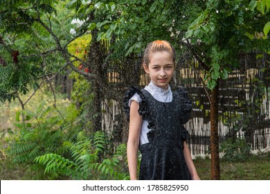 Wet Schoolgirl Standing In The Rain. Girl Wet. Teenager In School Uniform In Spring Or Warm Autumn. Girl 5th Grade. Hair Coloring. Portrait Of A Schoolgirl With Splashes Of Water. Back To School