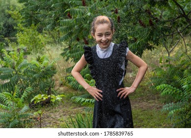 Wet Schoolgirl Standing In The Rain. Girl Wet. Teenager In School Uniform In Spring Or Warm Autumn. Girl 5th Grade. Hair Coloring. Portrait Of A Schoolgirl With Splashes Of Water. Back To School