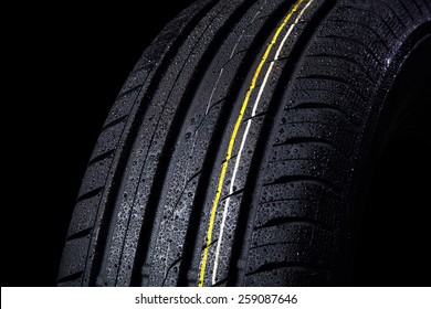 wet tire with asymmetric tread, close-up on a black background