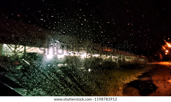 Wet the window with the background of the autumn
night city. Selective focus.
