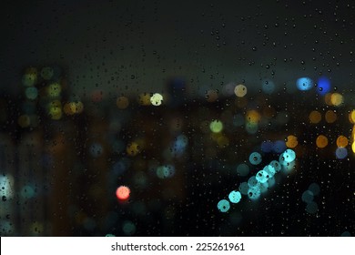 Wet The Window With The Background Of The Night City Traffic View.