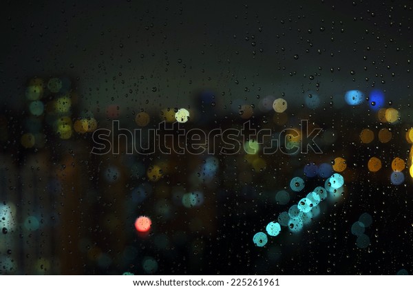 Wet the window with the background of the night\
city traffic view.