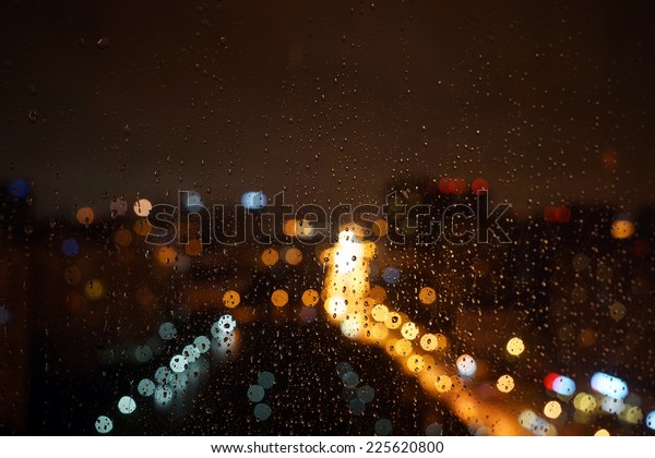 Wet the window with the background of the night\
city traffic view.